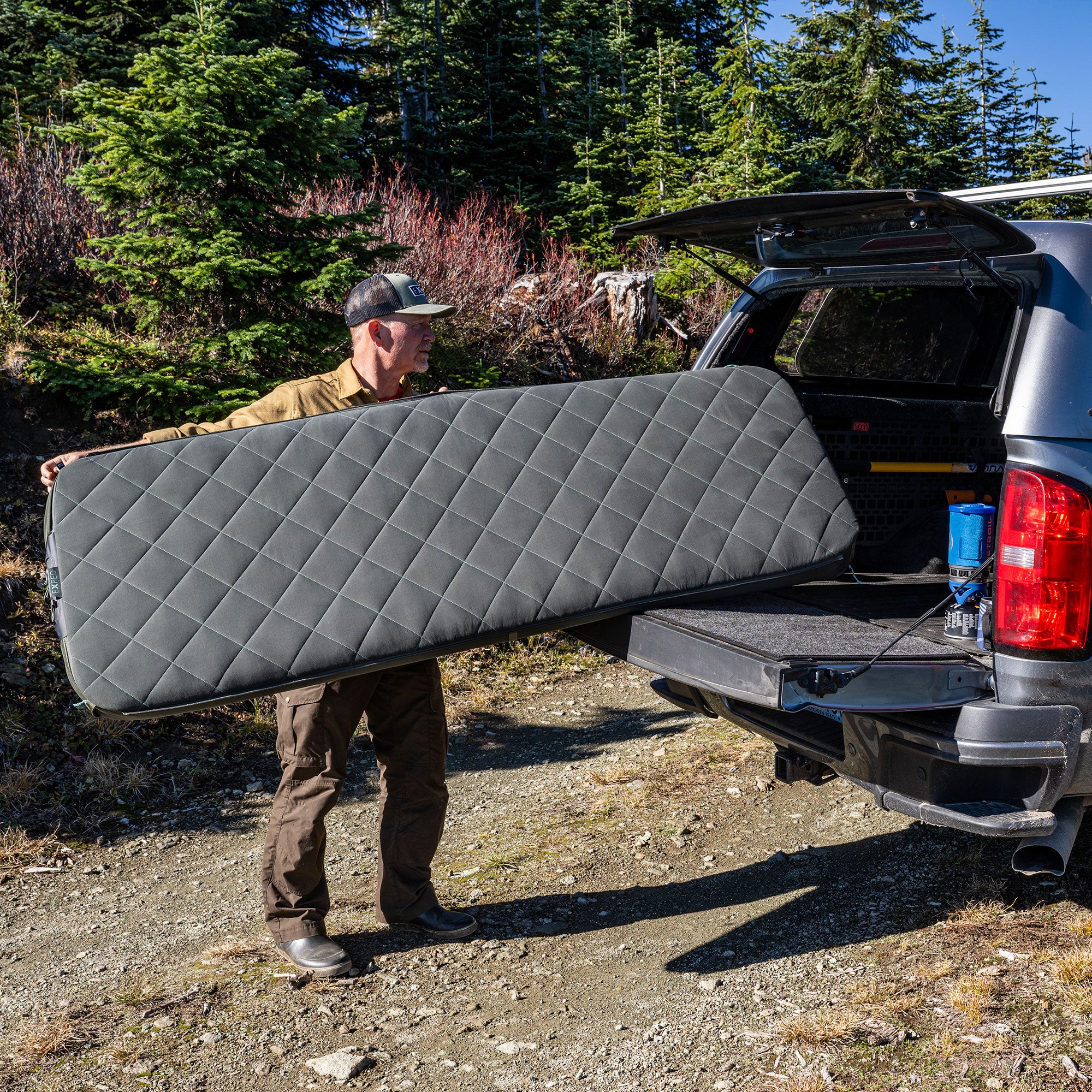Man carrying EXPED Luxemat in to van